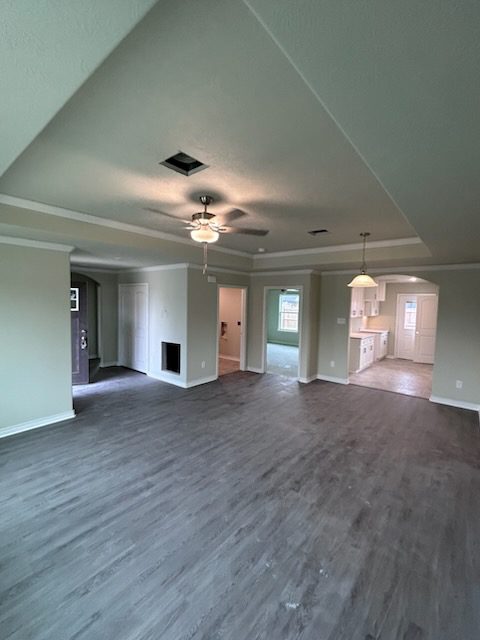 Spacious empty living room with ceiling fan.