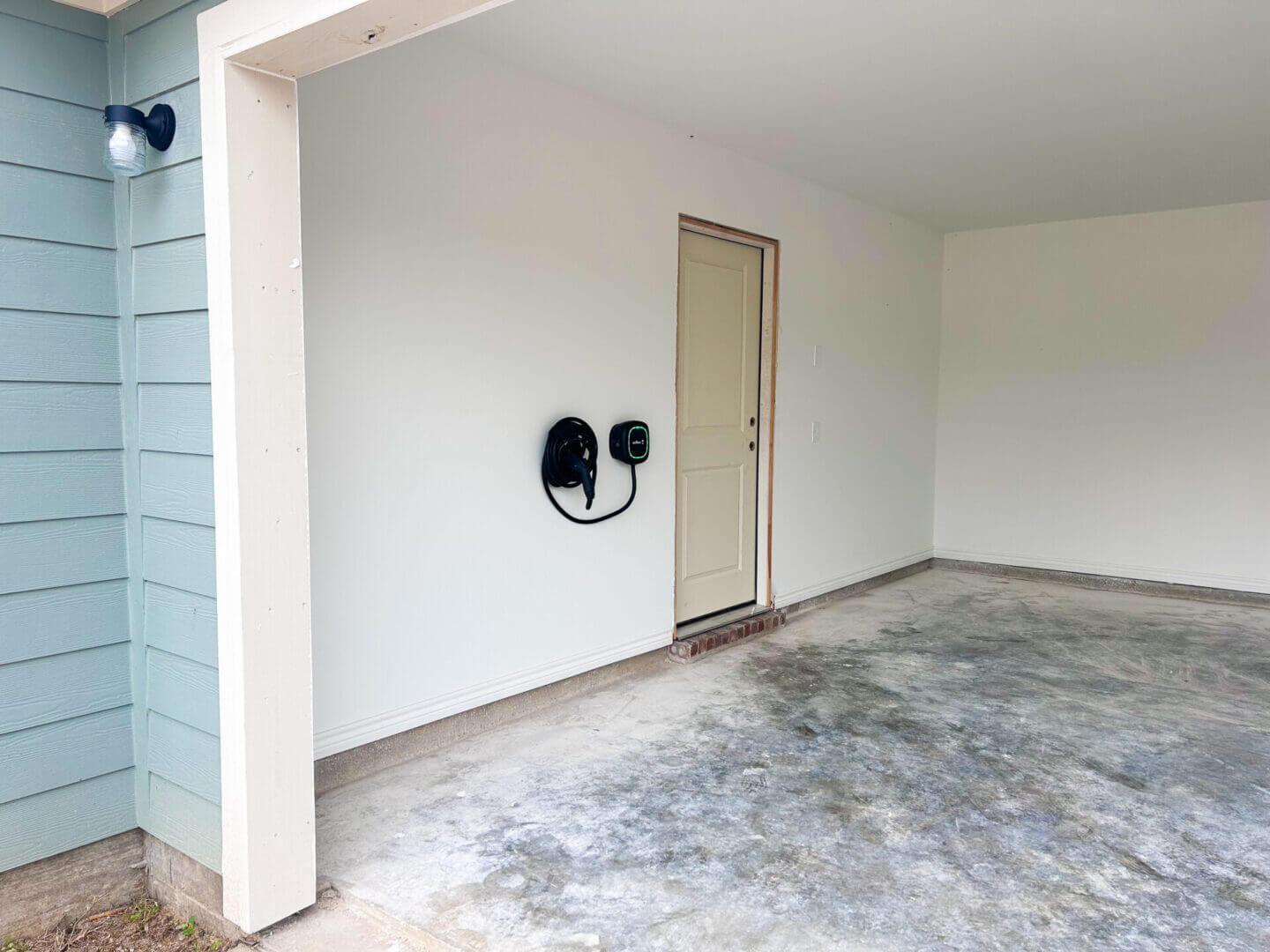 Empty garage with electric vehicle charger.