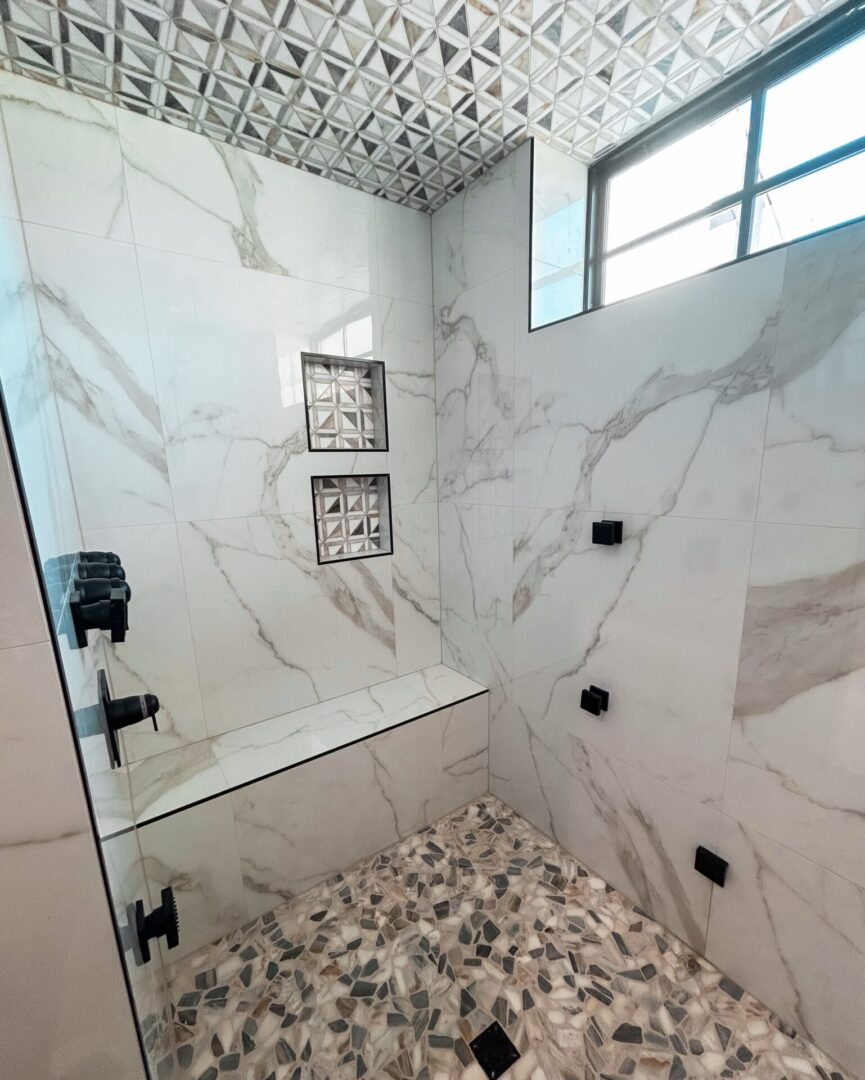 Marble shower with geometric ceiling pattern.
