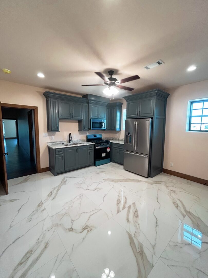 Modern kitchen with grey cabinets and appliances.